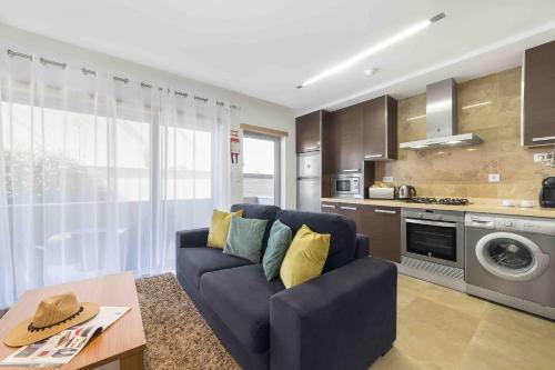 圣马蒂纽·杜·波特Baia Residence 3 - Holiday Apartments - By SCH的一间带蓝色沙发的客厅和一间厨房