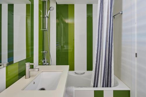 埃斯塔蒂特罗卡茅拉公寓的绿色和白色的浴室设有水槽和淋浴