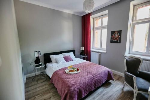 霍茹夫Beżowy Apartament DE LUX dla 4 osób Chorzów Katowice的一间卧室配有一张带紫色床罩的床
