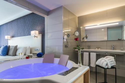 甘迪亚海滩埃斯金索滨海山庄公寓式酒店的一间位于客房内的带大型蓝色浴缸的浴室