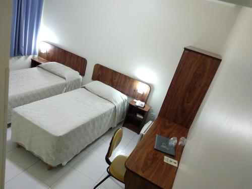 伊塔佩瓦Patriarca Hotel的酒店客房配有两张床和一张书桌