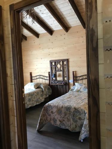 马德里德霍斯Casa rural Vega alta的小木屋内一间卧室,配有两张床