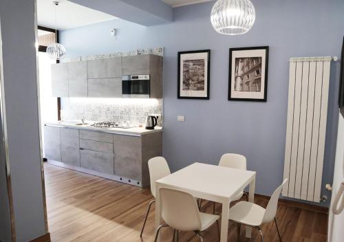 卡塞塔Residenza La Reggia的厨房以及带白色桌椅的用餐室。