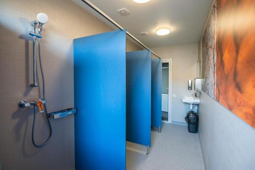 MežciemsHostel Sili的浴室配有蓝色淋浴间和盥洗盆