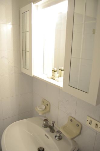 马西亚娜马里纳勒斯皮亚格公寓的白色的浴室设有水槽和镜子