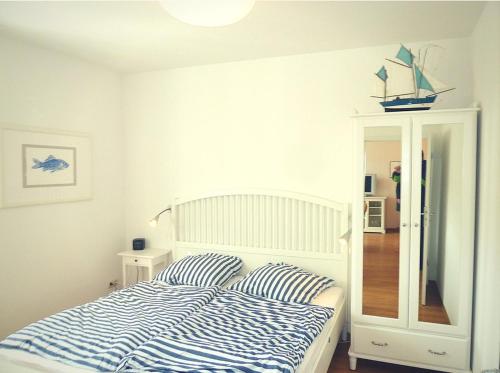奥斯赛拜-屈隆斯博恩Ferienwohnung Beach Loft im Haus Kühlung的一间卧室配有一张带蓝色和白色条纹枕头的床