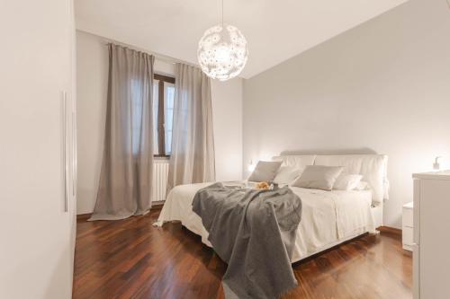 瓦雷多Welcome to Milan and More!的白色卧室配有一张床和一个吊灯