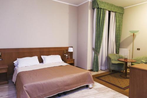 萨利切泰尔梅克莱门蒂酒店的配有一张床和一把椅子的酒店客房