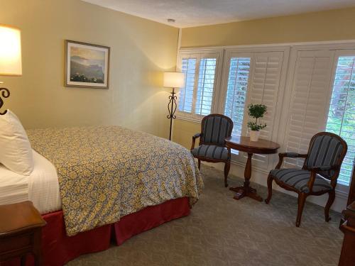 卡梅尔诺曼底旅馆的酒店客房配有一张床、两把椅子和一张桌子