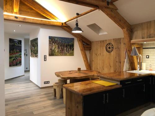 Husseren-WesserlingLa Datcha du Parc的厨房设有木墙和木桌