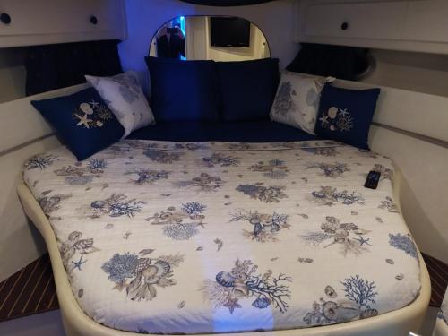 圣雷莫Sanremo charter boat and breakfast的一张带蓝色和白色床单及枕头的床