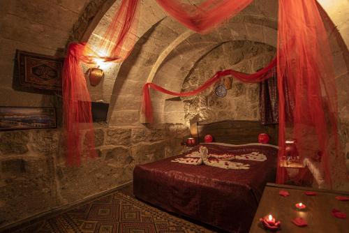 Guzelyurt卡帕多奇亚厄赫拉热峡谷洞穴酒店的石头间内一间卧室,配有一张床