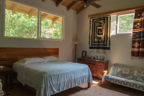 拉塞瓦Hotel Rio的一间卧室设有一张床和两个窗户。