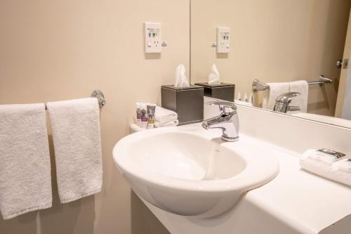 惠灵顿美居惠灵顿贝尔塔斯曼酒店的浴室设有白色水槽和镜子