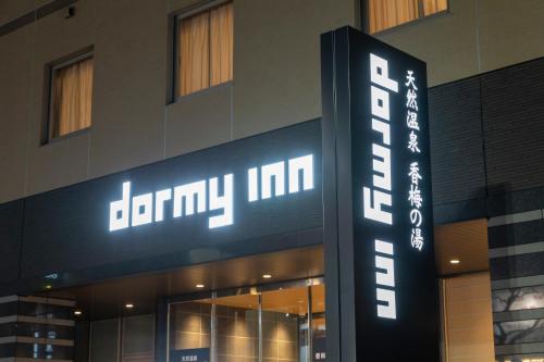 水户多米水户酒店(Dormy Inn Mito)的建筑物一侧的标志