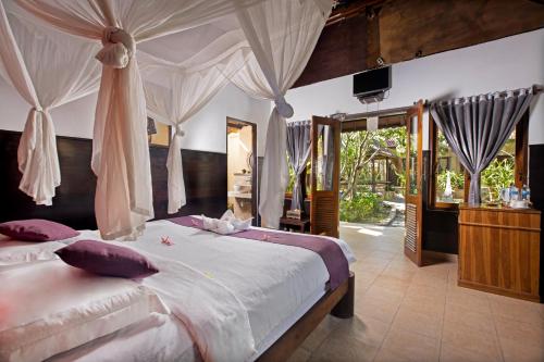 蓝梦岛The Tanis Beach Resort Nusa Lembongan的一间卧室配有一张带蚊帐的大床
