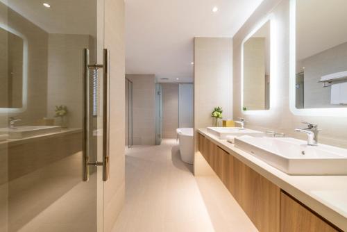 河内河内酒店的一间带两个盥洗盆、卫生间和镜子的浴室