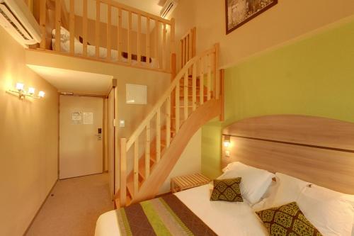 蒙布里松弗艾明星酒店的一间卧室设有一张床和一个楼梯