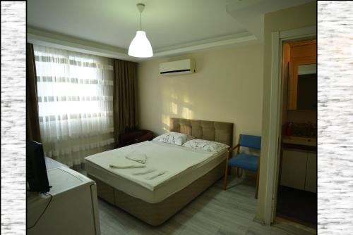 伊兹密尔Yeşilyurt Residence的一间卧室配有一张床和一张蓝色椅子