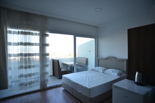 伊兹密尔Yeşilyurt Residence的一间卧室设有一张床和一个大型玻璃窗
