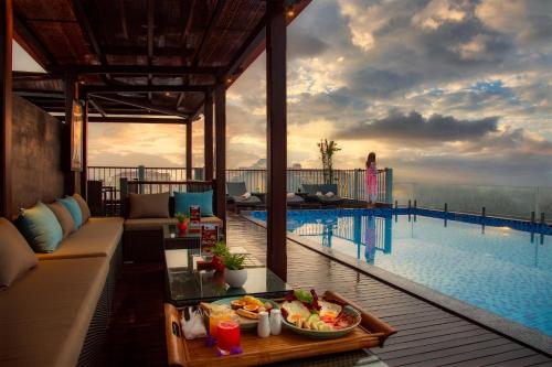 会安Cozy Savvy Boutique Hotel Hoi An的一个带游泳池和一张桌子的度假村