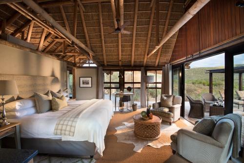 格拉罕镇Kwandwe Great Fish River Lodge的一间带一张大床的卧室,位于带窗户的房间内