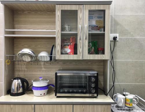 峇株巴辖Batu Pahat Leisure Stay的厨房的台面上有一个微波炉