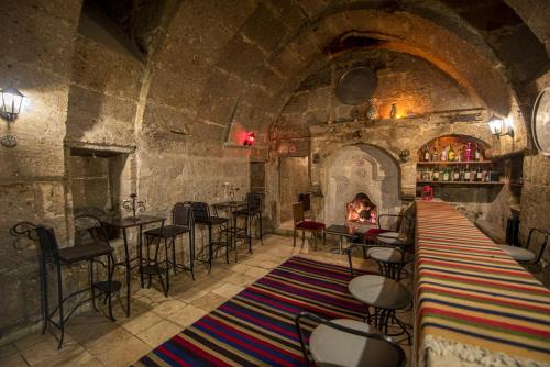 Guzelyurt阿基尼孔奇酒店的石头建筑中带壁炉的酒吧