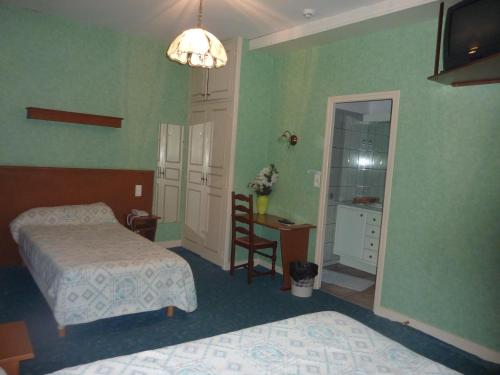 勒比格巴黎酒店的一间卧室配有两张床、一张桌子和一面镜子