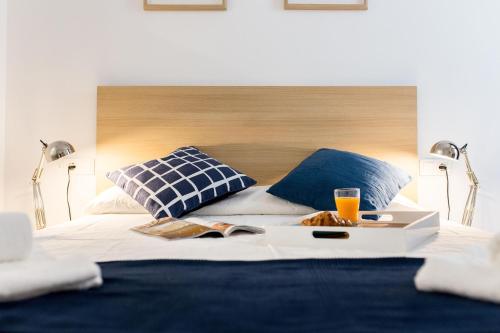 瓦伦西亚Oceanográfico Apartments的一张带两个枕头的床和一盘食物