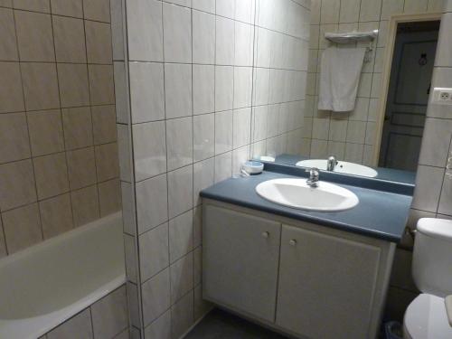 勒比格巴黎酒店的浴室配有盥洗盆、卫生间和浴缸。