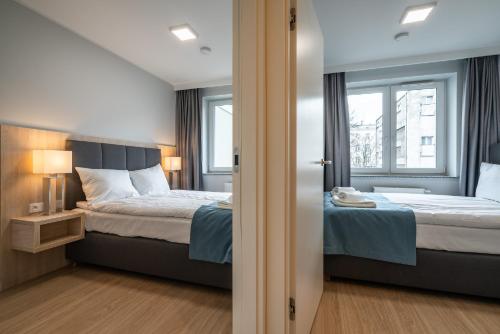 弗罗茨瓦夫Q19 Apartments Old Town的一间卧室设有两张床和窗户。