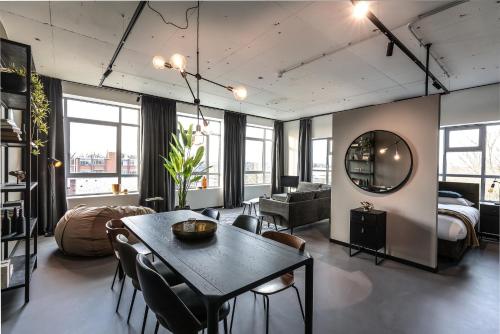 希佛萨姆Hilversum City Apartments的一间带桌子的客厅和一间卧室