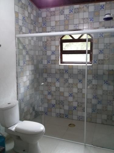 伯迪亚哥Suites próximo ao rio Jaguareguava em Bertioga的一间带卫生间和玻璃淋浴间的浴室
