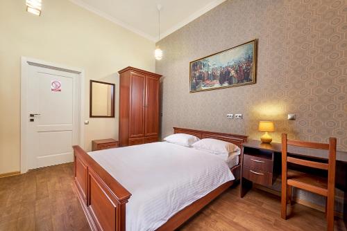 利沃夫哥萨克旅馆 的一间卧室配有一张床、一张桌子和一张图片