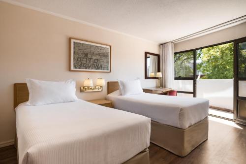 蒙得维的亚蒙得维迪亚戴斯酒店的酒店客房设有两张床和窗户。