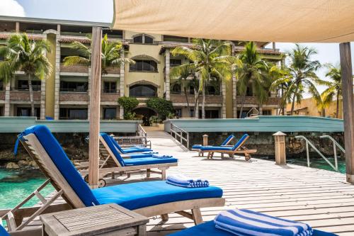 克拉伦代克The Bellafonte - Luxury Oceanfront Hotel的一个带蓝色躺椅的甲板和一个游泳池