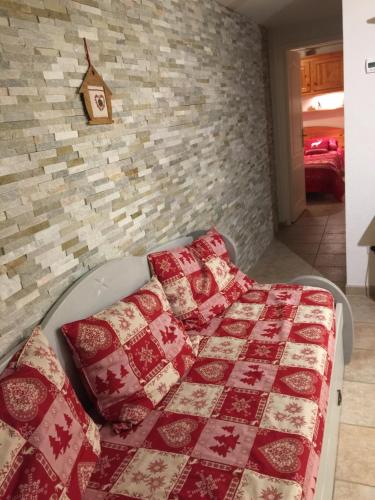 CrévouxL'étable的一间卧室配有红色和白色的毯子