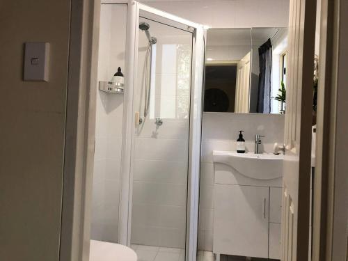悉尼Escape to Strathfield for 8 guests的带淋浴和盥洗盆的白色浴室