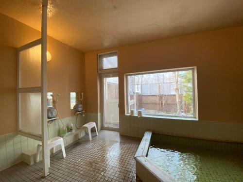 弟子屈町斯帕鲁弟子屈町酒店的带浴缸和水池的浴室。