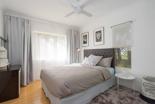 悉尼Urban Escape – Strathfield的一间卧室配有一张床和吊扇