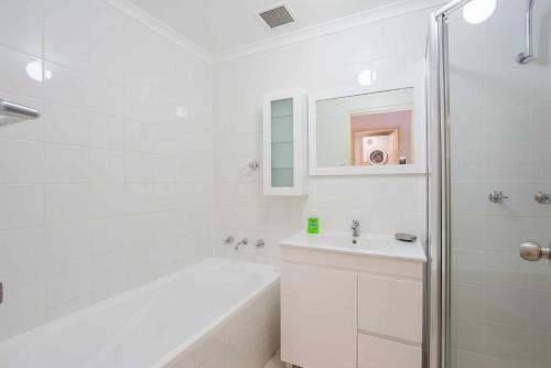 悉尼Urban Escape – Strathfield的白色的浴室设有浴缸和水槽。