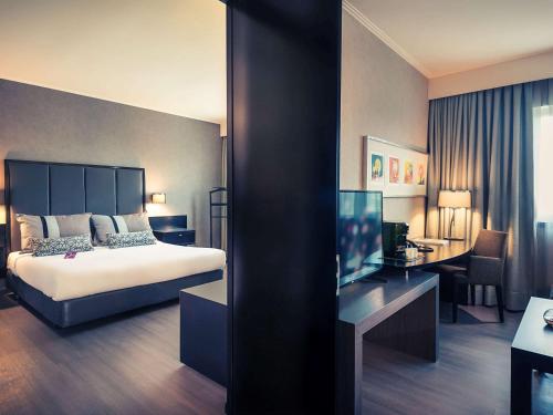 圣地亚哥圣地亚哥中心美居酒店的配有一张床和一张书桌的酒店客房
