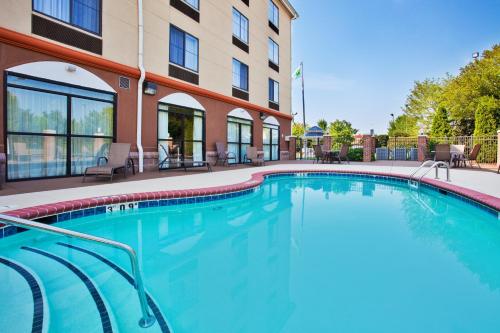 康科德Holiday Inn Express & Suites Charlotte-Concord-I-85, an IHG Hotel的大楼前的游泳池