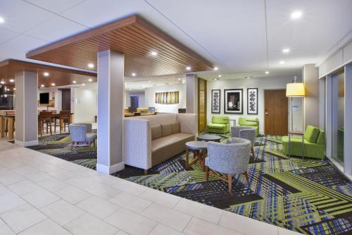 大急流城Holiday Inn Express & Suites Grand Rapids Airport North, an IHG Hotel的大堂配有沙发、椅子和桌子