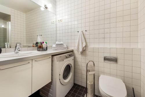 奥斯陆Tjuvholmen I, As Home的白色的浴室设有洗衣机和水槽。