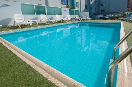伊塔佩马伊塔佩马索利斯海滩酒店的一座带椅子的大型蓝色游泳池