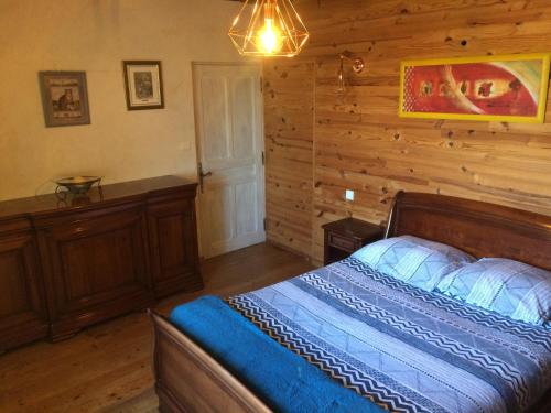 CharmesLe Maquis的一间卧室设有一张床和木墙