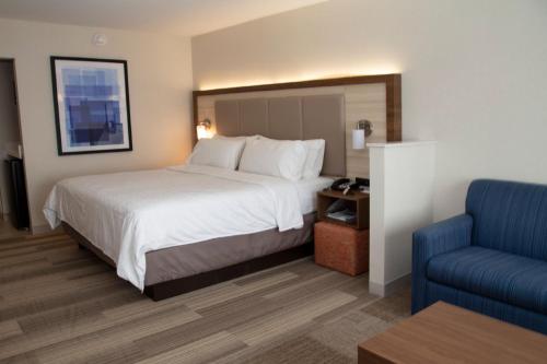 马里恩Holiday Inn Express & Suites - Marion, an IHG Hotel的酒店客房,配有一张床和一张蓝色椅子