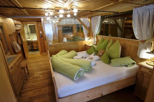沃瑟姆阿尔伯格Biobauernhof Gehrnerhof am Arlberg的船中间的一张床铺,配有绿色枕头